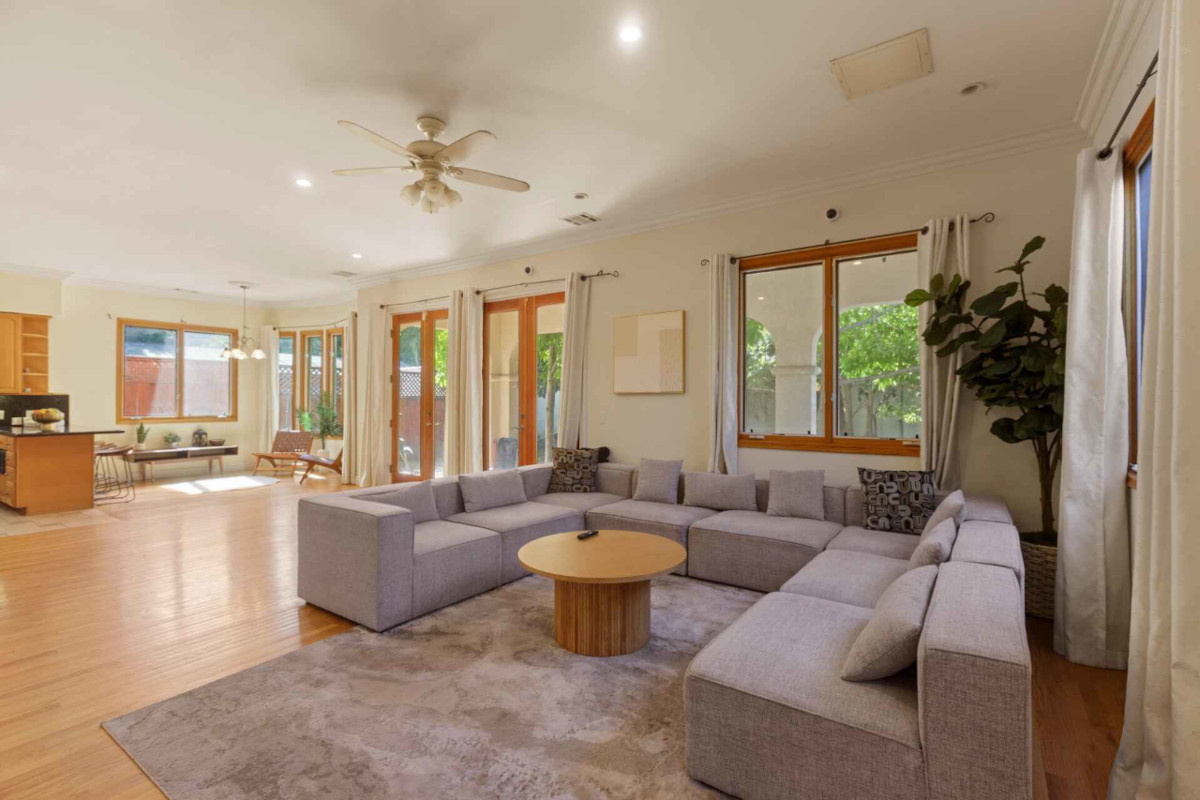 An inviting living room with a soft couch, a chic coffee table, and a sliding glass door that opens to a scenic view Tulua - Almayo Ave