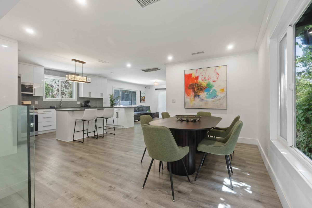 A stylish kitchen and dining area showcasing sleek design elements and beautiful hardwood flooring, exuding modern elegance Tulua - The Military Ave