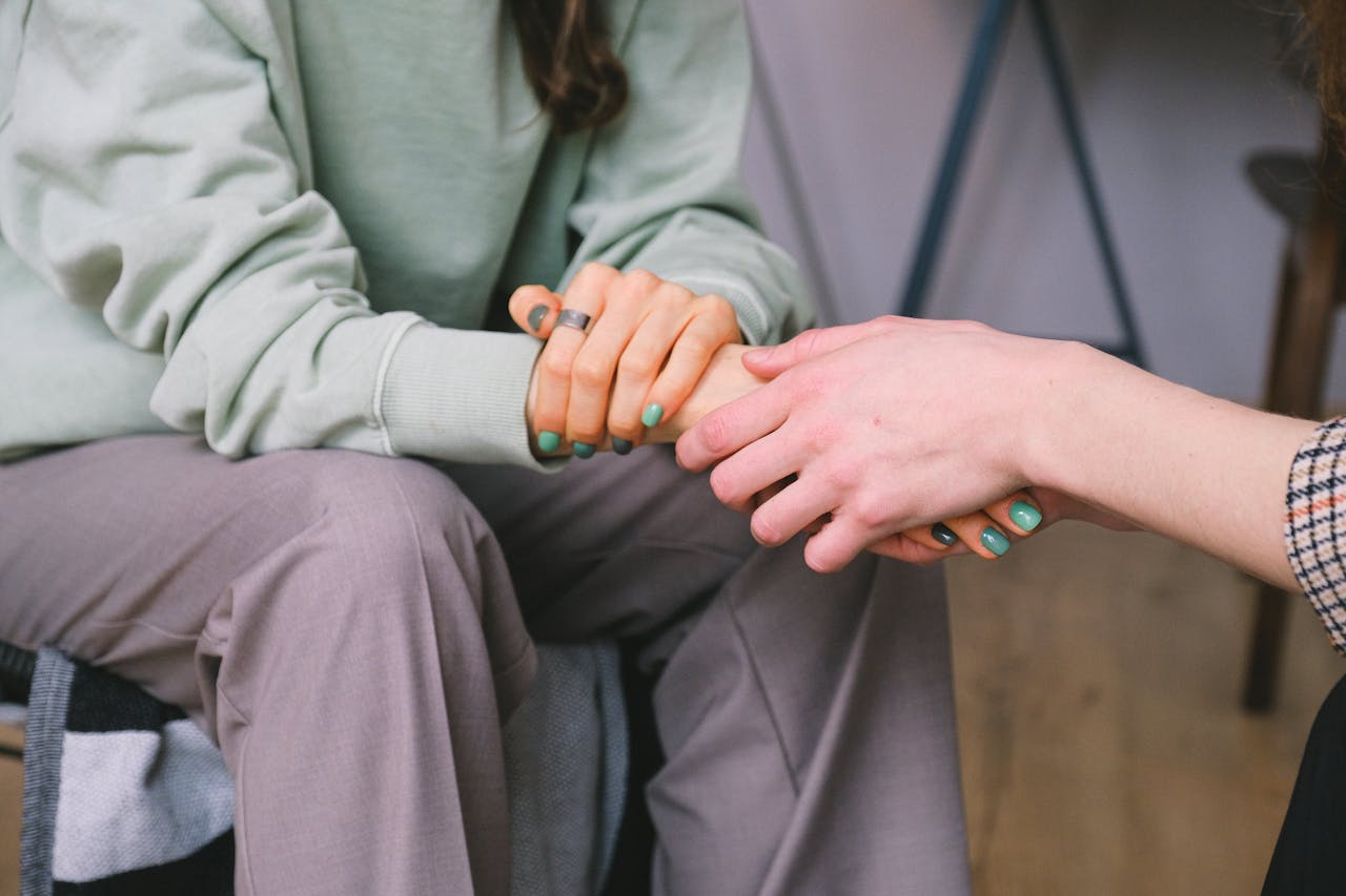 two women holding hands in psychotherapy