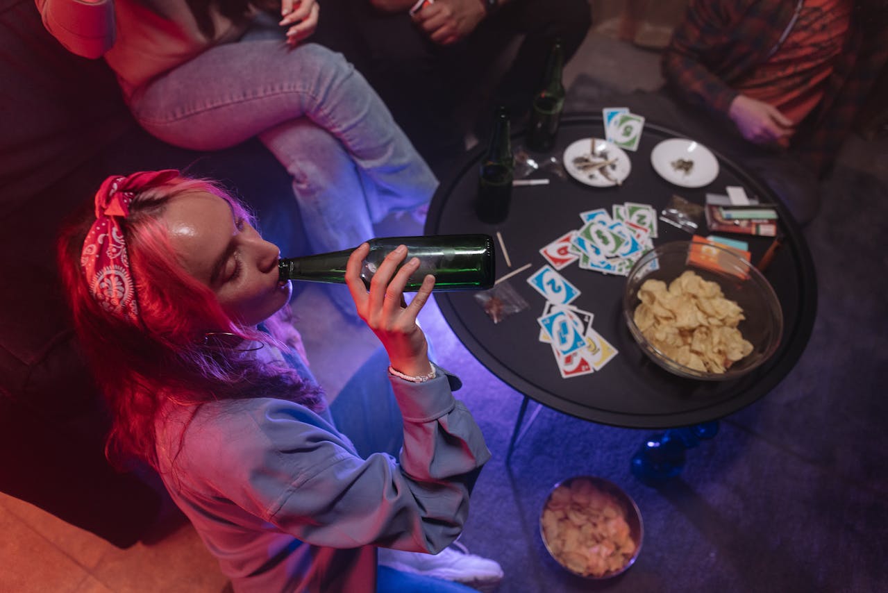 Young girl drinking beer, smoking weed at a home party