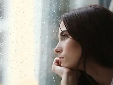 woman looking sad through the window